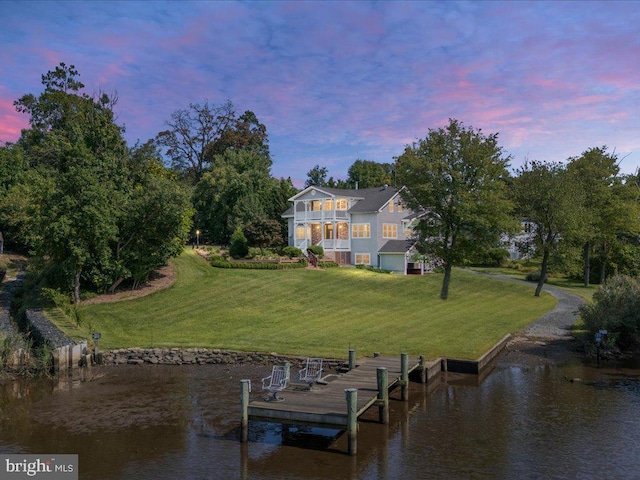 dock area featuring a lawn, a water view, and a balcony