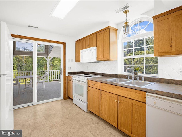 kitchen featuring decorative backsplash, sink, pendant lighting, and white appliances