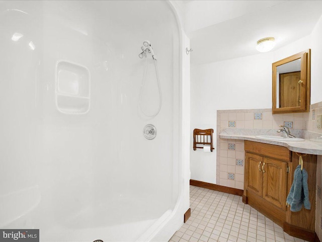 bathroom with tasteful backsplash, tile patterned flooring, and vanity