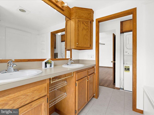 interior space featuring tile patterned flooring, stacked washer / drying machine, and vanity