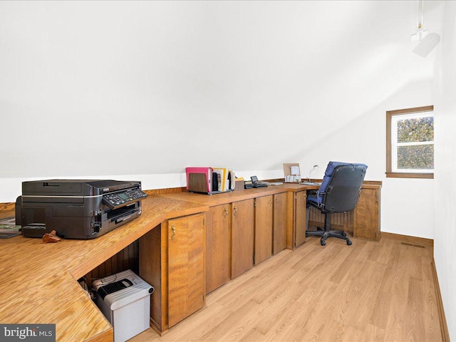 home office featuring vaulted ceiling and light hardwood / wood-style flooring