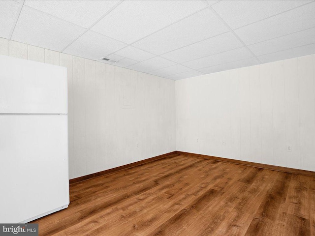 empty room featuring a paneled ceiling and hardwood / wood-style flooring