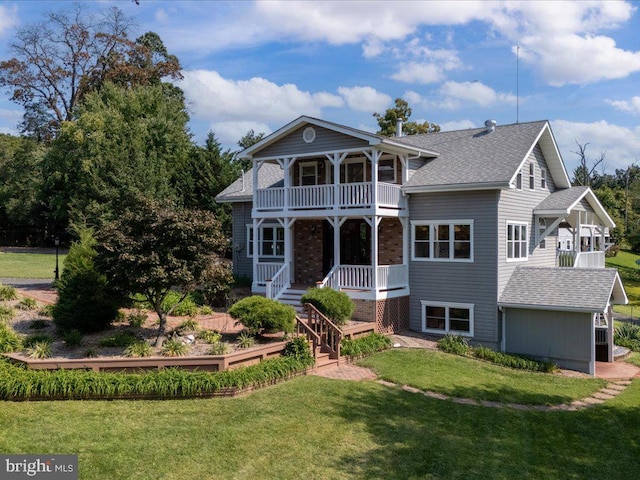 view of front facade featuring covered porch, a balcony, and a front lawn