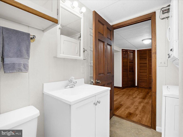 bathroom featuring washer / dryer, vanity, toilet, and hardwood / wood-style floors