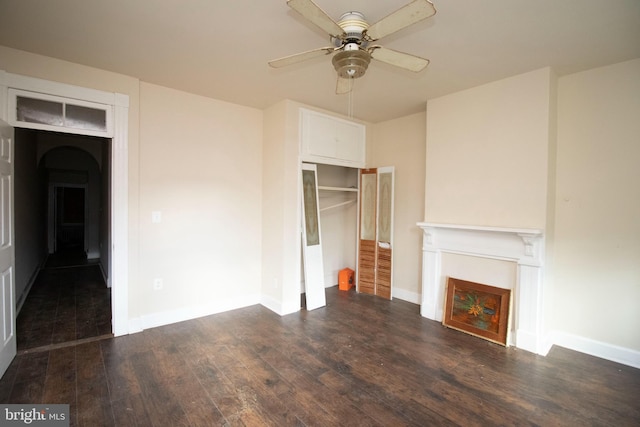 unfurnished living room featuring ceiling fan and dark hardwood / wood-style floors