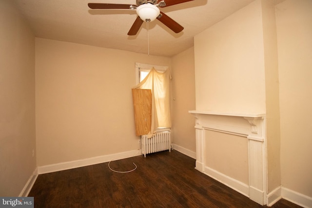 empty room with ceiling fan, radiator heating unit, and dark hardwood / wood-style floors