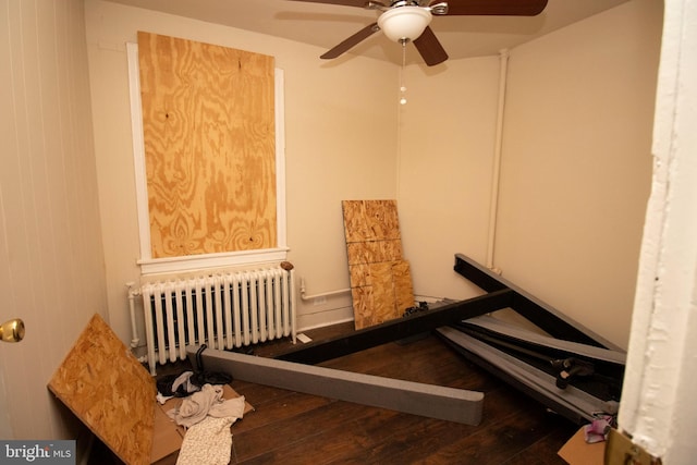 stairs featuring hardwood / wood-style flooring, ceiling fan, and radiator heating unit