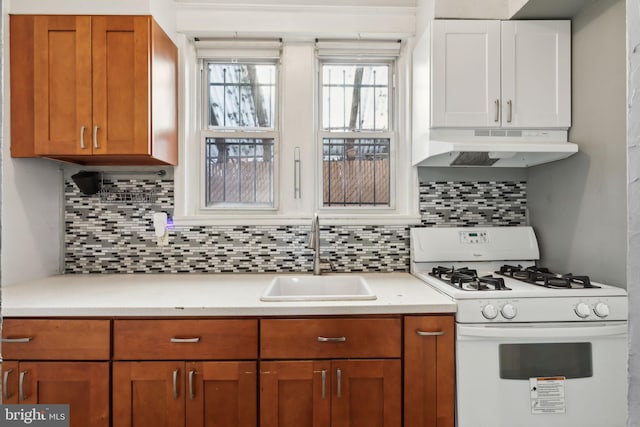 kitchen featuring tasteful backsplash, gas range gas stove, and sink