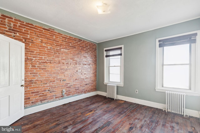 unfurnished room with a wealth of natural light, dark hardwood / wood-style flooring, and radiator