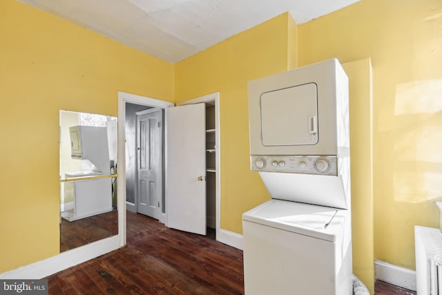 washroom with dark hardwood / wood-style flooring and stacked washer and clothes dryer