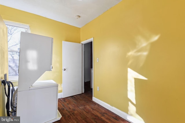 washroom with stacked washer / dryer and dark hardwood / wood-style flooring