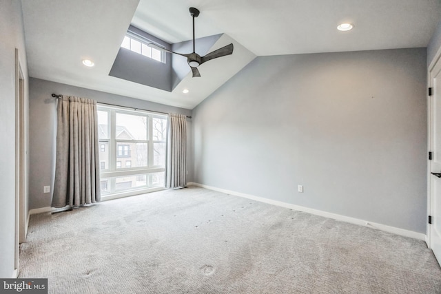 empty room featuring ceiling fan, high vaulted ceiling, and light colored carpet