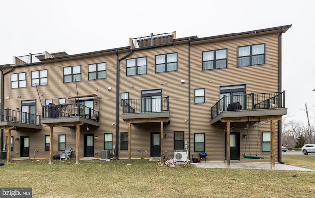 rear view of house featuring a patio area, ac unit, a yard, and central AC