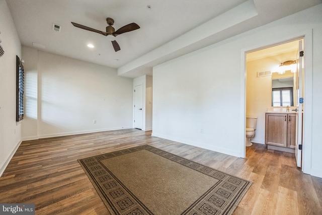 empty room with sink, hardwood / wood-style flooring, and ceiling fan