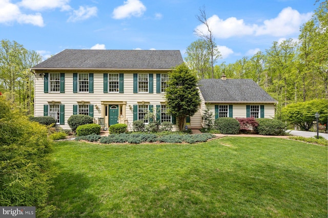 colonial home featuring a front yard