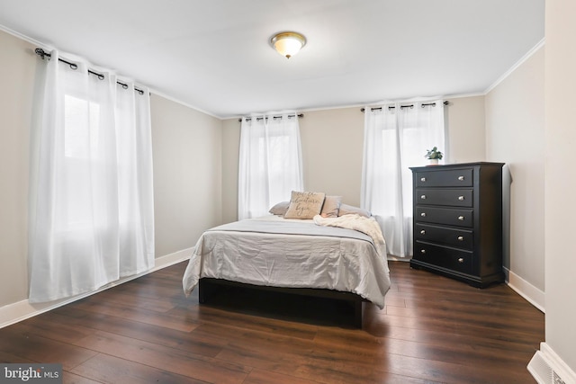 bedroom with ornamental molding, dark wood-style flooring, and baseboards