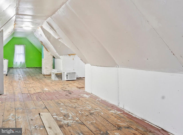 additional living space featuring lofted ceiling and hardwood / wood-style floors