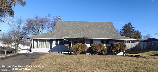 view of front facade featuring a sunroom and a front lawn