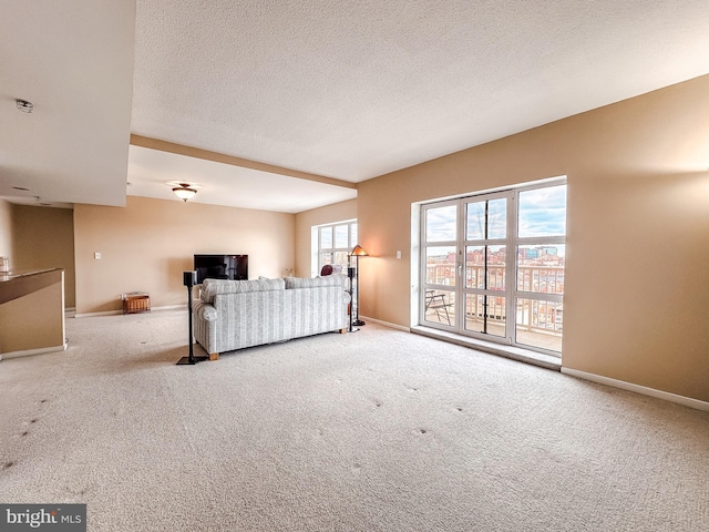 unfurnished living room with carpet and a textured ceiling