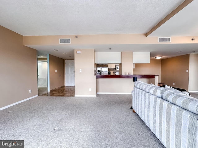 carpeted living room featuring a textured ceiling