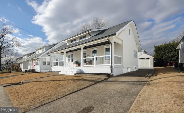 view of front of property with a porch, a garage, and an outdoor structure