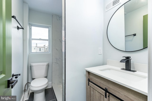 bathroom with a shower, vanity, and toilet