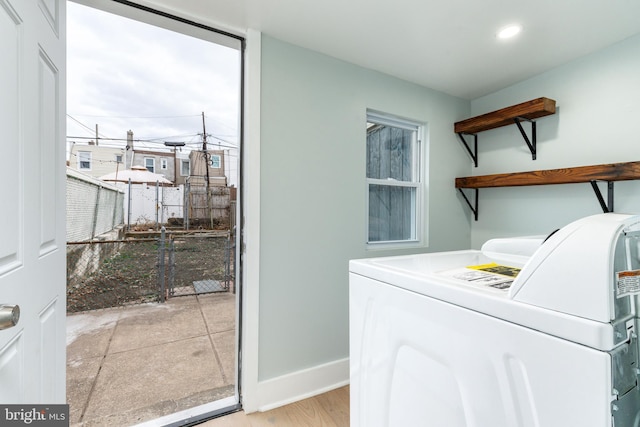 laundry room with washer / dryer and light hardwood / wood-style flooring