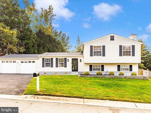 tri-level home featuring a garage and a front lawn