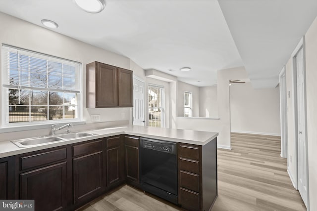 kitchen with dishwasher, kitchen peninsula, sink, and light hardwood / wood-style flooring