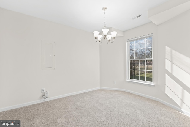 unfurnished room featuring carpet flooring, electric panel, and a chandelier