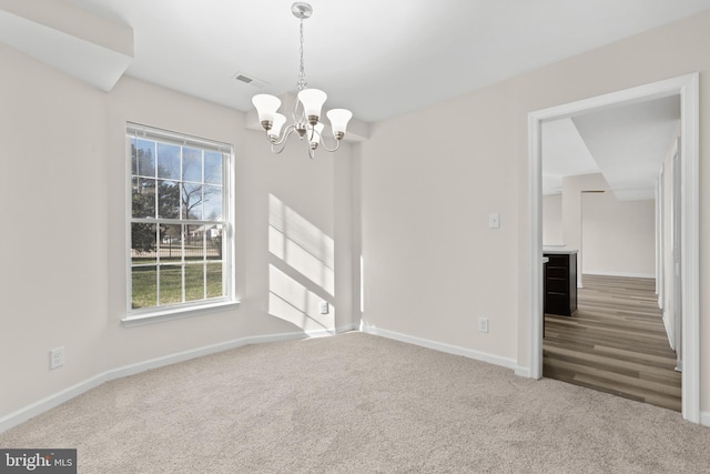 unfurnished room featuring carpet flooring and an inviting chandelier