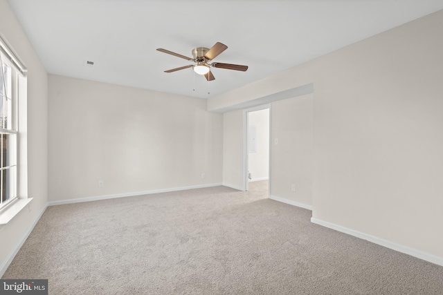 unfurnished room featuring light carpet, plenty of natural light, and ceiling fan