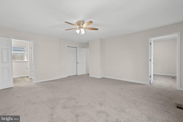 carpeted spare room with ceiling fan