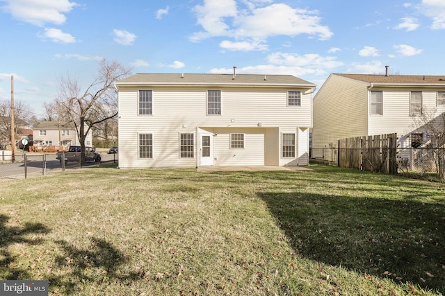 back of house with a patio area and a lawn