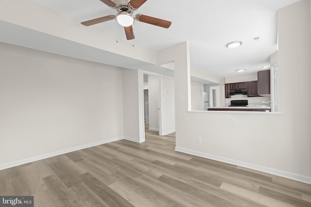 unfurnished living room with ceiling fan and light wood-type flooring