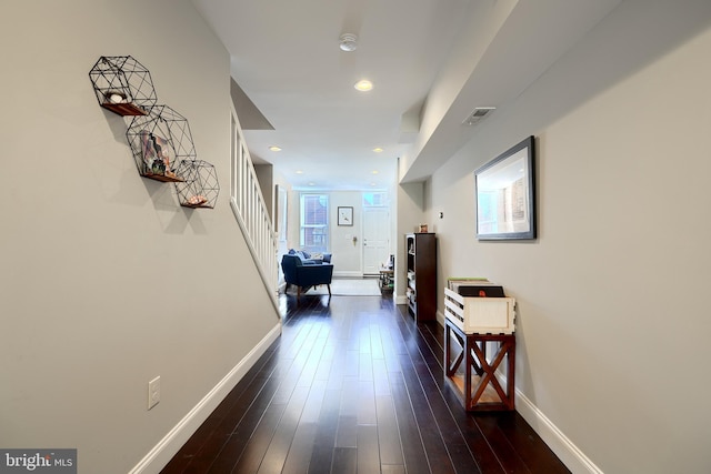 corridor with dark hardwood / wood-style flooring and a healthy amount of sunlight