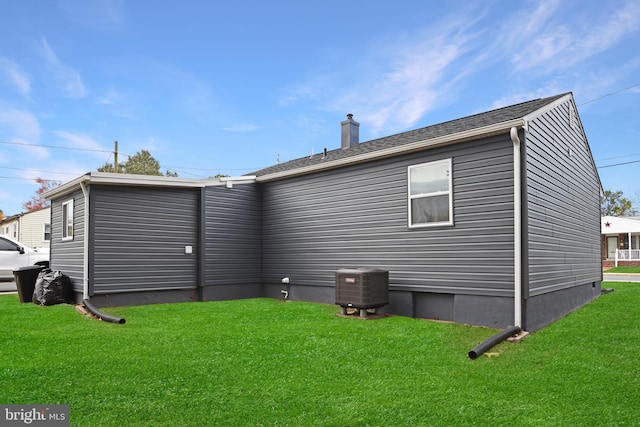 rear view of property with a yard and cooling unit