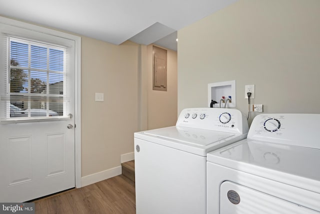 laundry area featuring independent washer and dryer, electric panel, and light hardwood / wood-style flooring