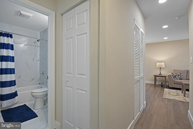 bathroom featuring shower / tub combo with curtain, wood-type flooring, and toilet