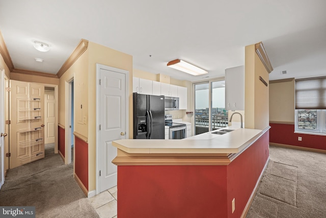 kitchen with white cabinets, appliances with stainless steel finishes, light colored carpet, and sink