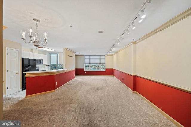 interior space featuring light carpet, white cabinets, ornamental molding, black fridge with ice dispenser, and a chandelier