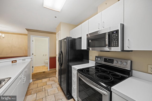 kitchen with sink, a notable chandelier, crown molding, white cabinets, and appliances with stainless steel finishes