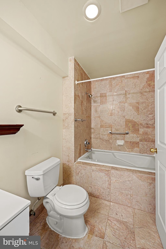 bathroom with toilet and tiled shower / bath