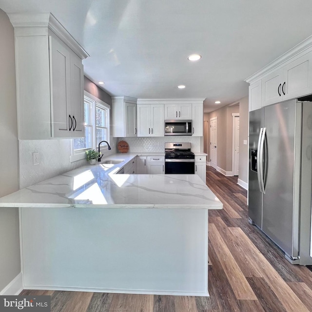 kitchen featuring kitchen peninsula, stainless steel appliances, and sink