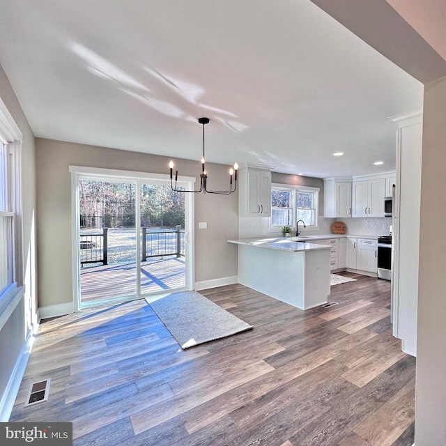 kitchen with backsplash, sink, decorative light fixtures, white cabinetry, and stainless steel appliances