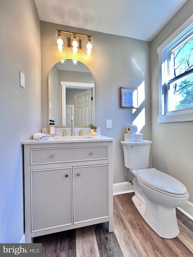 bathroom featuring wood-type flooring, vanity, and toilet