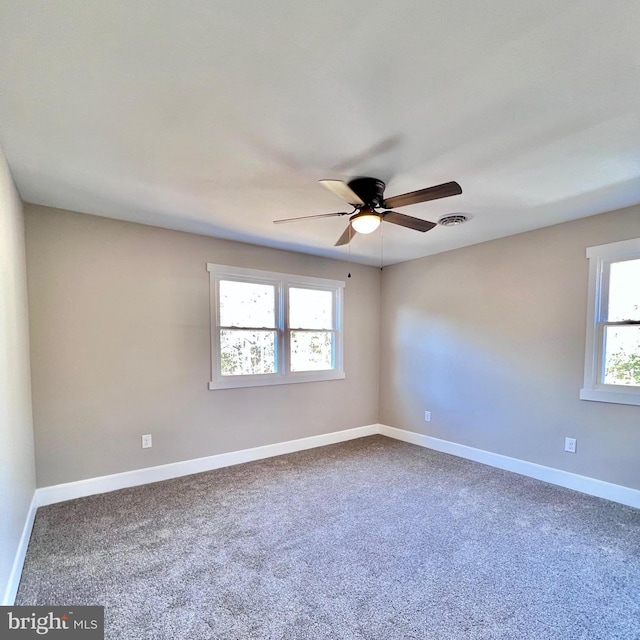 carpeted spare room with ceiling fan