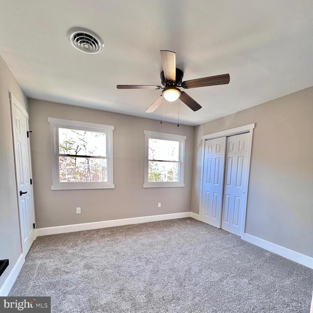 unfurnished bedroom with carpet flooring, ceiling fan, and a closet