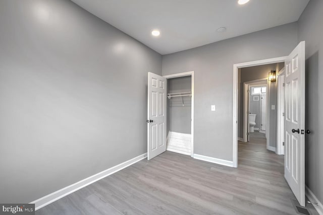 unfurnished bedroom with light hardwood / wood-style floors and a closet