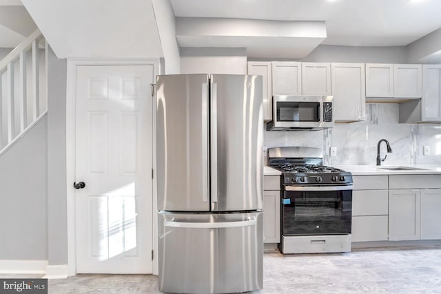 kitchen with appliances with stainless steel finishes, tasteful backsplash, and sink